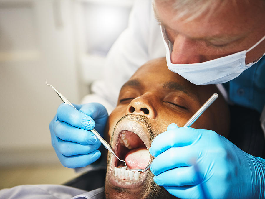 Dentist working on patients teeth Photograph by RapidEye