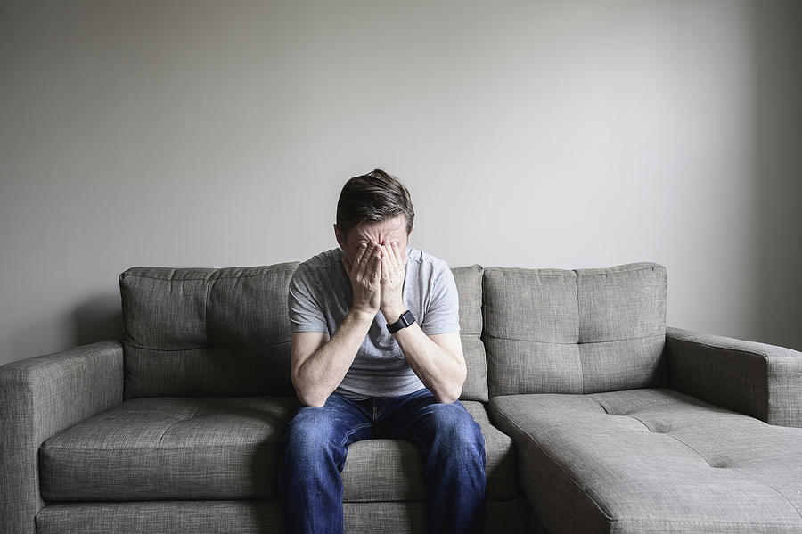 Depressed mature man sitting on couch Photograph by Dermot Conlan