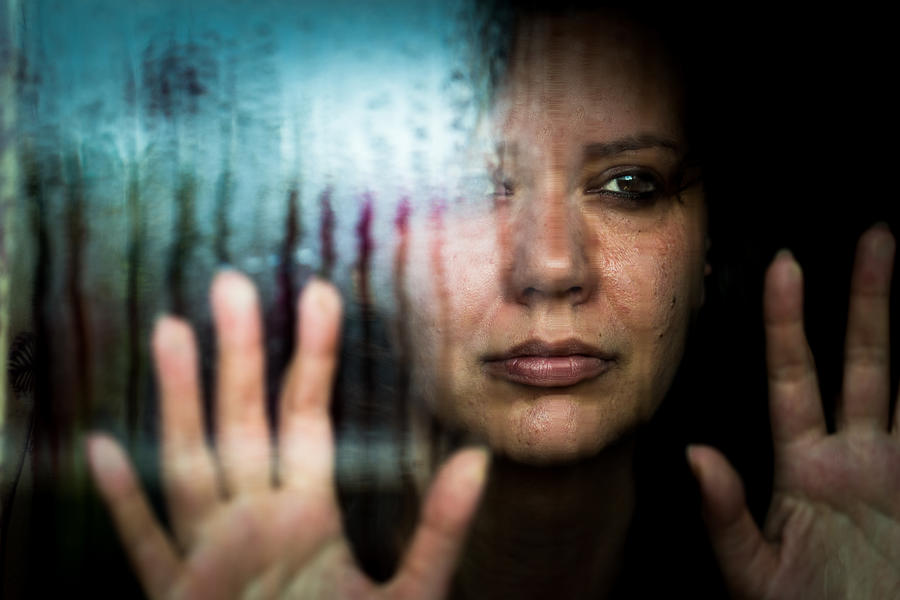 Depressed woman looking out of rainy window Photograph by Coldsnowstorm