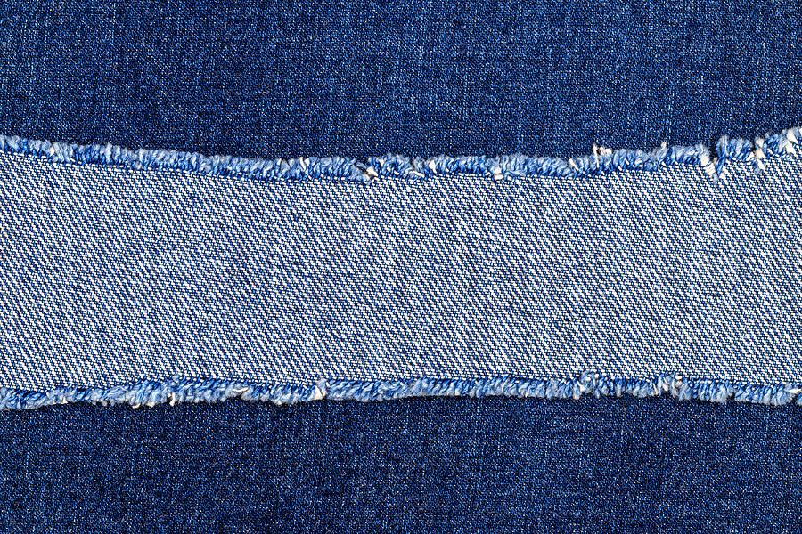 Destroyed torn denim blue jeans fabric frame on blue jeans background ...