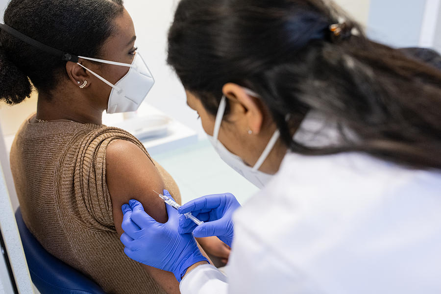 Detail view of a woman being vaccinated by a doctor in a medical clinic Photograph by Luis Alvarez