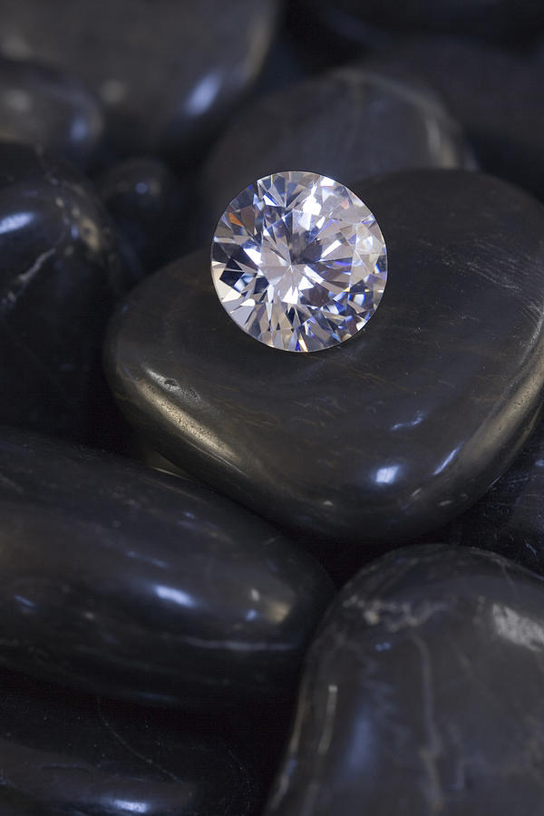 Diamond resting on stones Photograph by Comstock Images