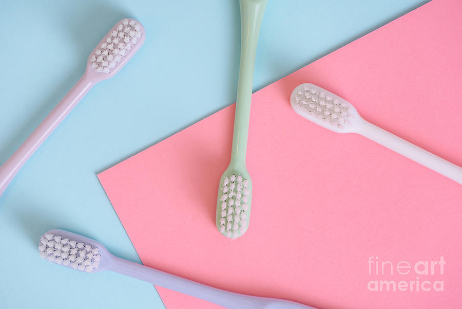Different pastel tooth brushes pattern on color background. Many Photograph by Jelena Jovanovic