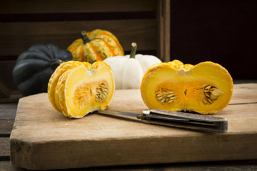 Different sorts of mini squashes with sliced Jack be Little in the foreground Photograph by Westend61
