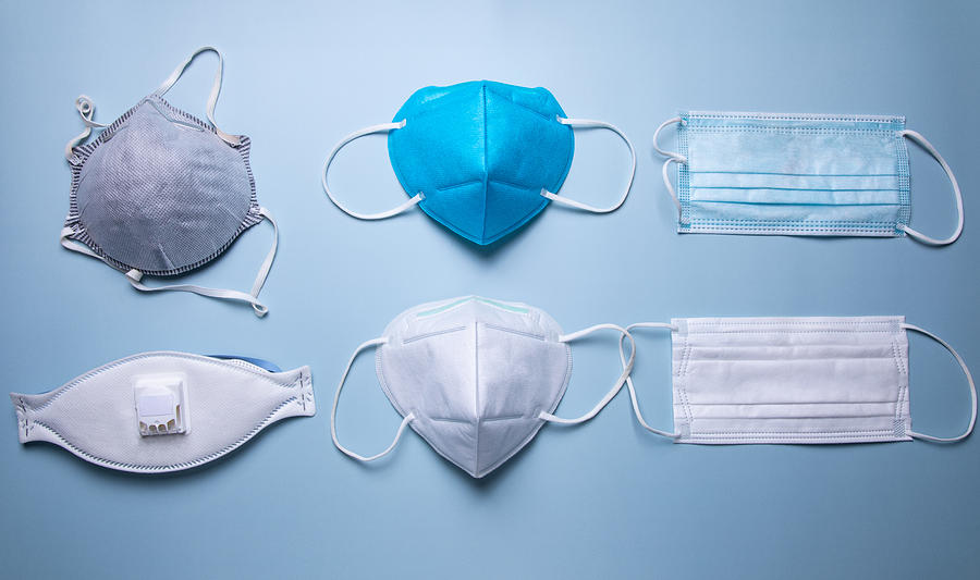 Different Types Of Protective Face Mask Against Blue Background Photograph by Kilito Chan