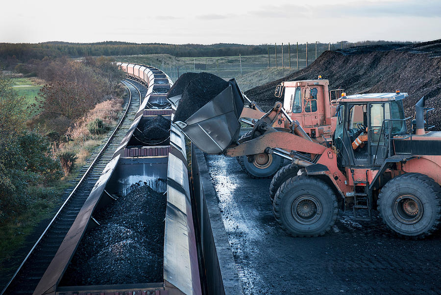 Diggers loading coal onto train at surface coal mine at dawn Photograph by Monty Rakusen
