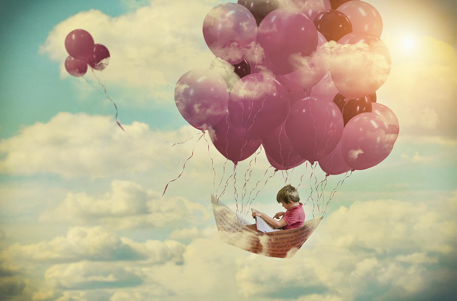 Digital composition, of a boy flying on a paper boat fastened by pink balloons Photograph by Juana Mari Moya