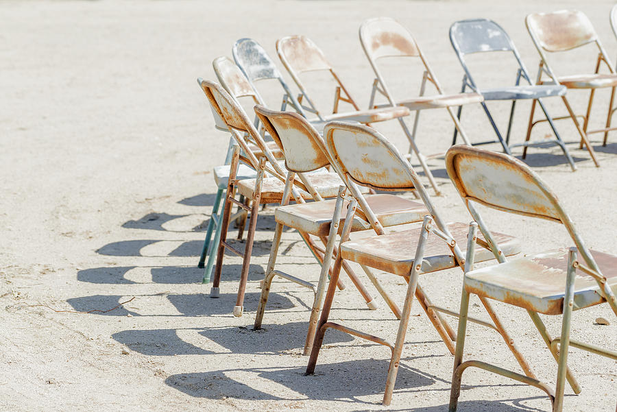 Dilapidated chairs arranged in circle in dirt field Photograph by Chris Clor