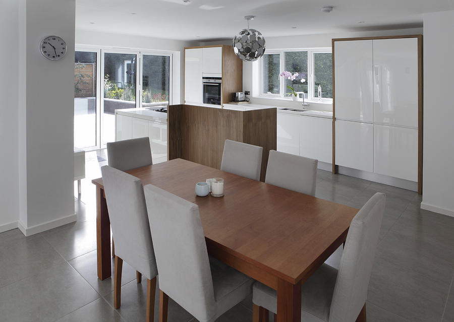 Dining table in open plan house Photograph by Image Source