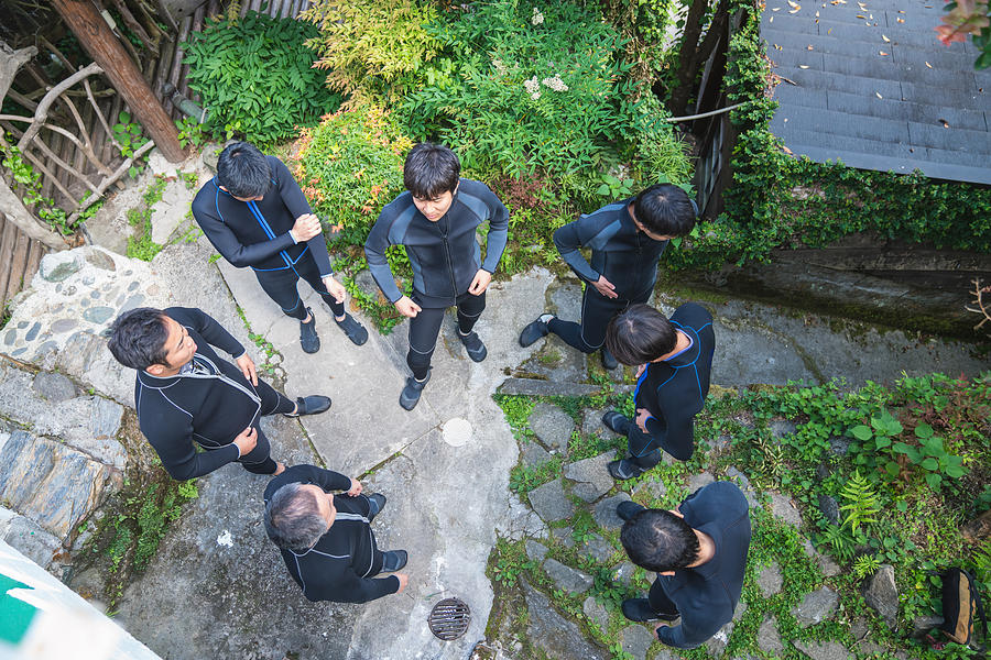Directly above view of a group of men wearing wet suits before a river rafting tour Photograph by Tdub303
