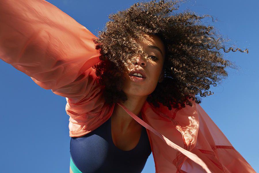 Directly below shot of female athlete with curly hair against clear sky Photograph by Klaus Vedfelt
