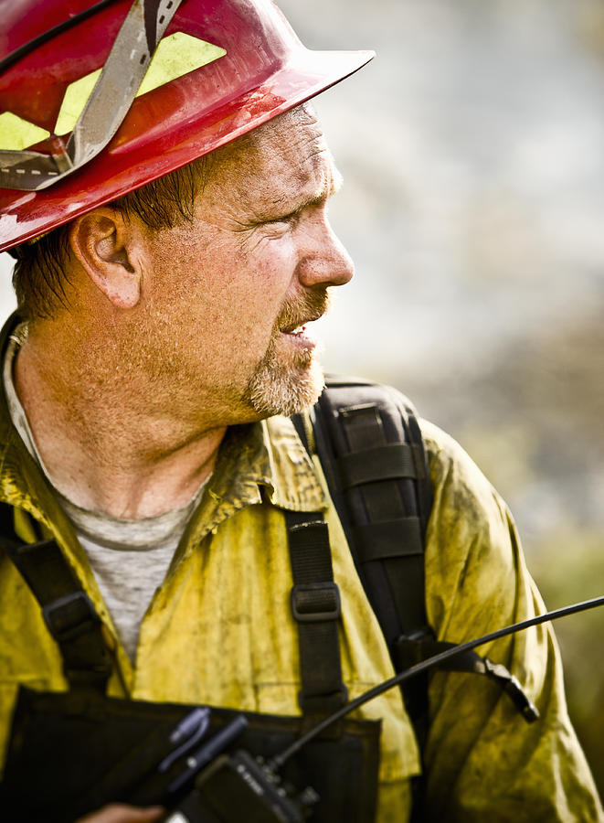 Dirty firefighter with radio, close-up Photograph by Tyler Stableford
