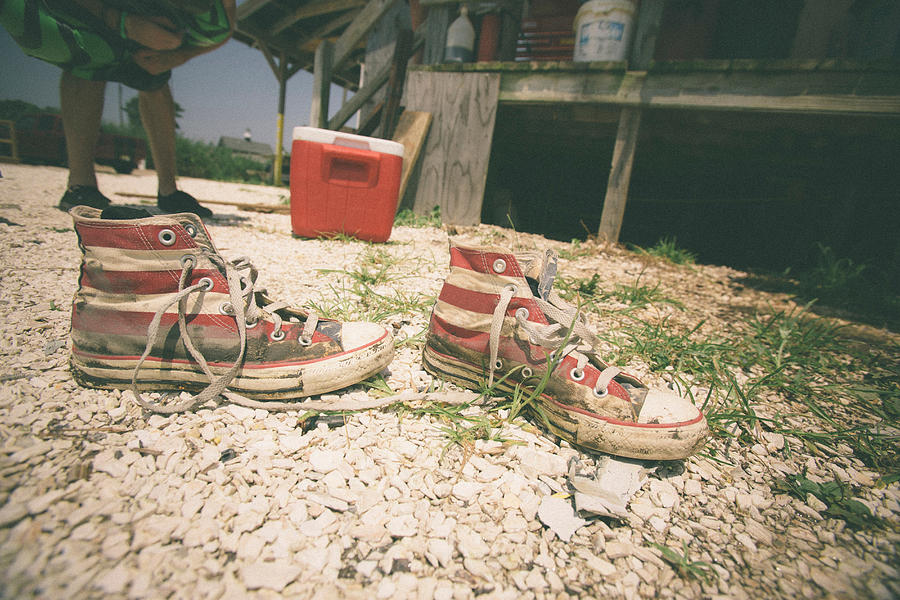 Dirty red and white striped baseball boots Photograph by Cultura RM Exclusive/Chris Sembrot