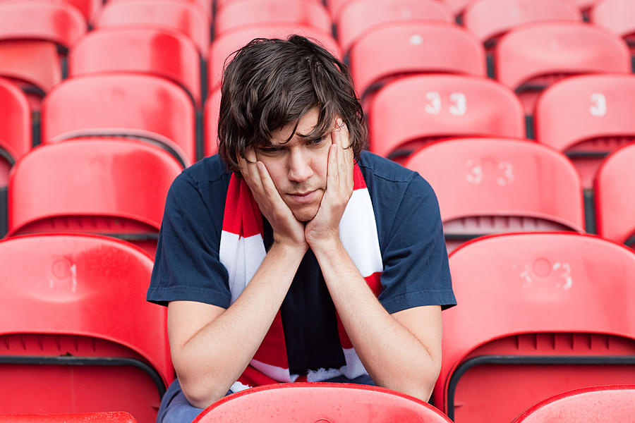 Disappointed football fan in empty stadium Photograph by Image Source