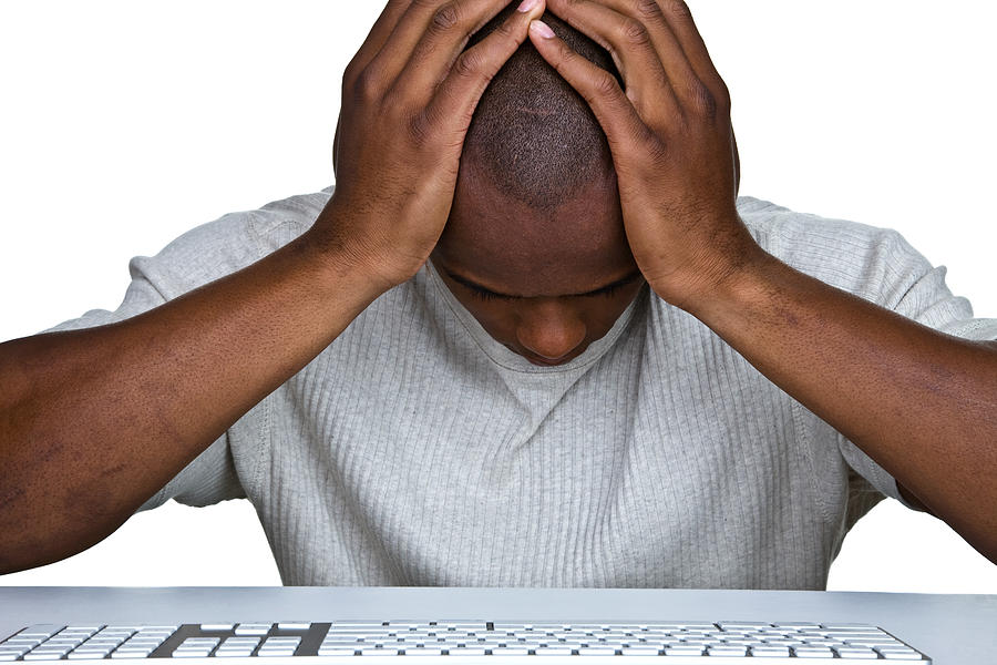 Discouraged man sitting in front of a computer Photograph by Stockphoto4u