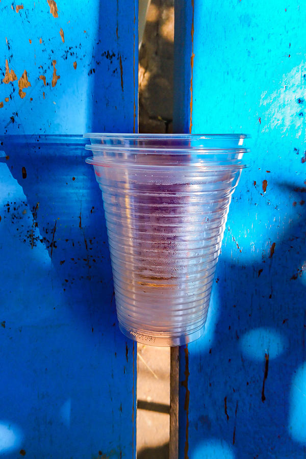 Disposable clear plastic cups left in a public bench. Photograph by CRMacedonio