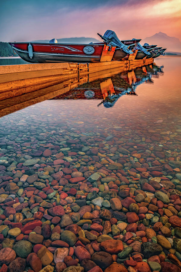 Docked Boats And Colorful Rocks Of Lake McDonald Montana Photograph by Gregory Ballos