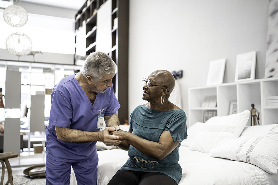Doctor consoling a patient, holding hands Photograph by FG Trade