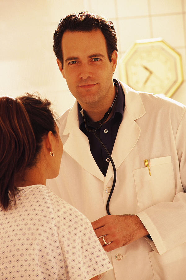 Doctor examining young woman Photograph by Comstock