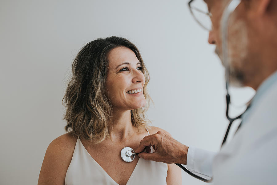 Doctor listening to patients heart with stethoscope Photograph by Andreswd