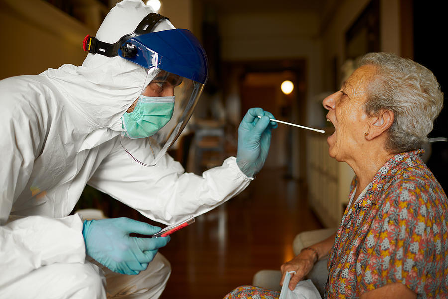 Doing a COVID test in full PPE wear at a seniors home. Photograph by Tempura