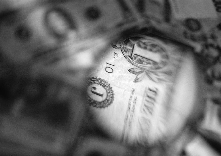 Dollar bill, seen through magnifying glass, close-up, b&w. Photograph by Frederic Cirou