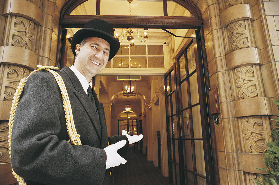 Doorman Gesturing Towards a Hotel Entrance Photograph by Karl Grupe