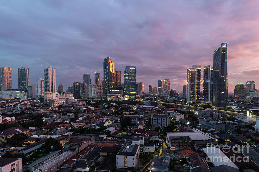 Dramatic sunset over Jakarta skyline where modern skyscrapers co ...