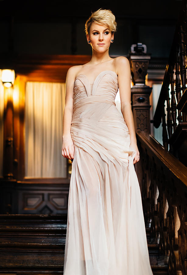 Dressed up woman in evening gown walking stairway to ballroom Photograph by Mlenny