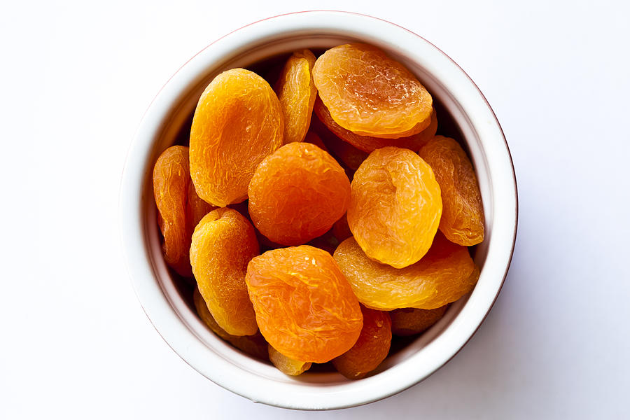 Dried apricots in bowl Photograph by Jenny Dettrick