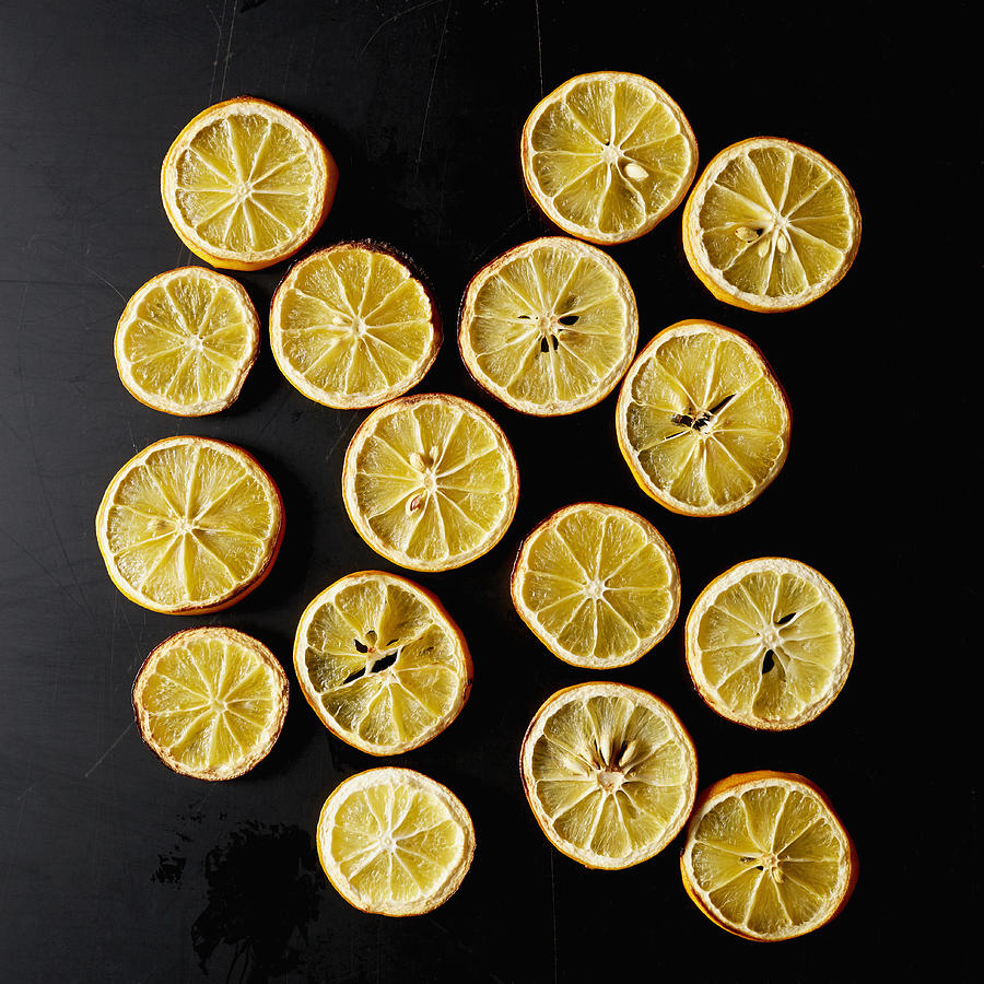 Dried lemon slices on black background Photograph by Winslow Productions