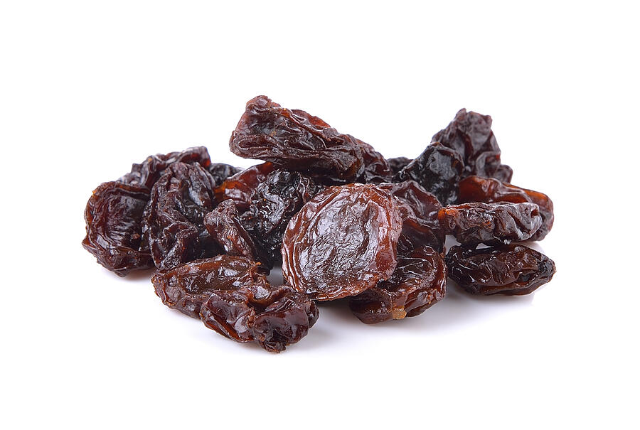Dried raisins on a white background Photograph by Sommail