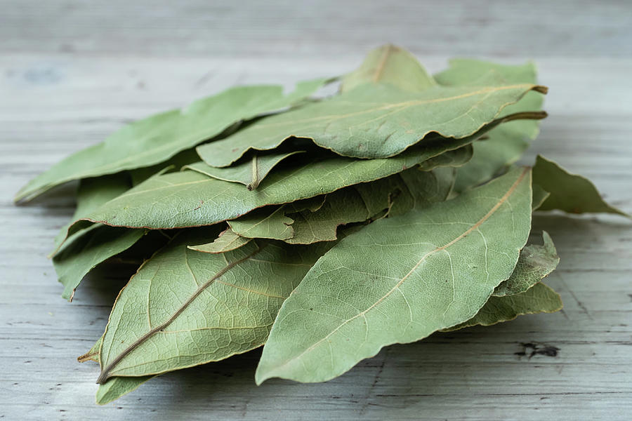 Dried whole bay leaves on cutting board Photograph by Lubos Chlubny ...