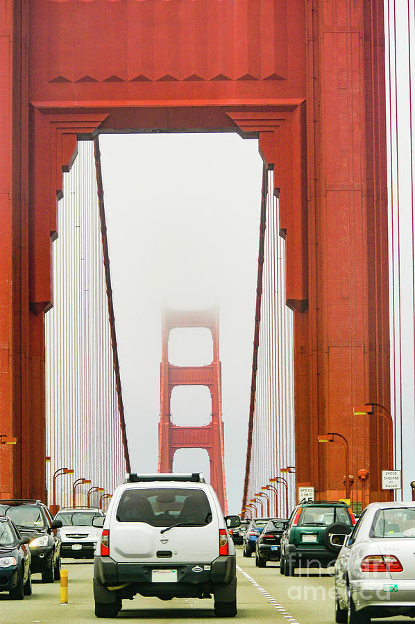 Driving into low clouds and fog on the Golden Gate Bridge Photograph by Gunther Allen