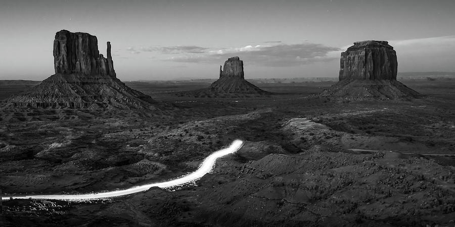Black And White Photograph - Driving Through Monument Valley at Dusk - Black and White Panorama by Gregory Ballos