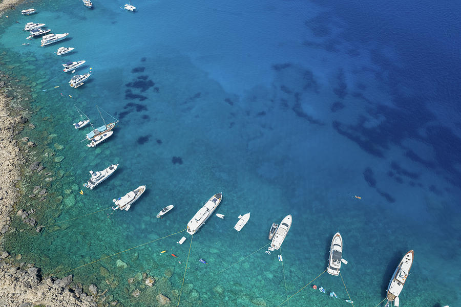 Drone aerial seascape luxury yachts moored in the coast and unrecognised people swimming relaxing. Summer vacations in the sea.  Photograph by Michalakis Ppalis