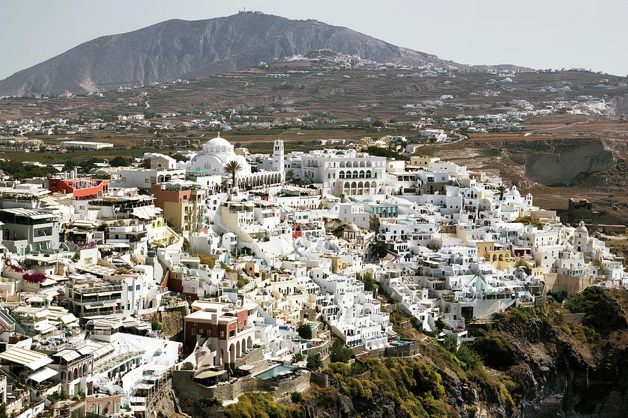 Drone Aerial shot of Thira village in Santorini, Oia located in Greece against mountains. Famous greek island cityscape Photograph by Arpan Bhatia