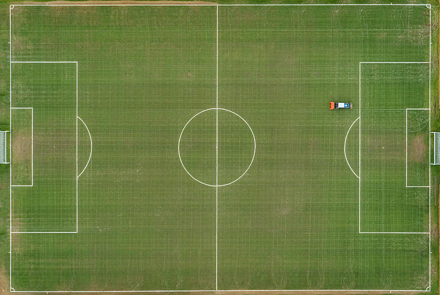 Drone point of view over a community grass football pitch Photograph by Justin Paget