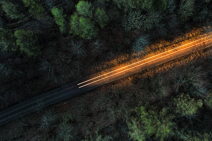 Drone view above a road through a forest at night Photograph by Justin Paget