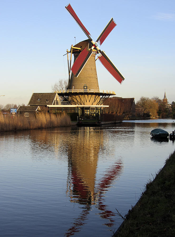 Dutch corn mill along canal, reflected in water Photograph by Roel_Meijer