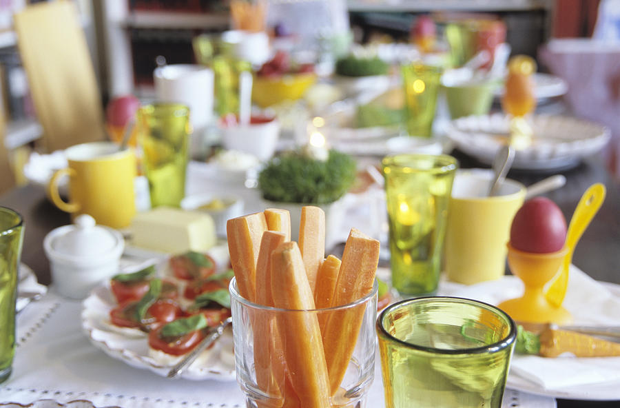 Easter table setting, focus on carrot slices in glass Photograph by Nico Hermann