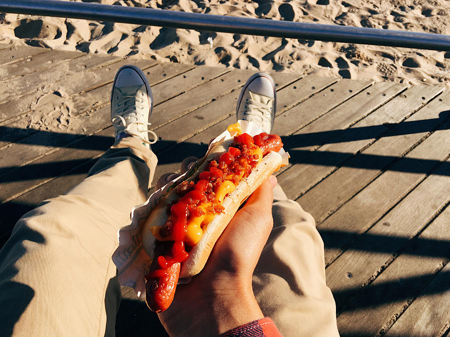 Eating famous New York hot dog at Coney Island Boardwalk, personal perspective Photograph by Alexander Spatari