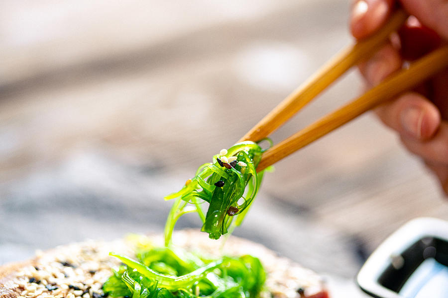 Eating seaweed salad with chopsticks Photograph by Da-kuk