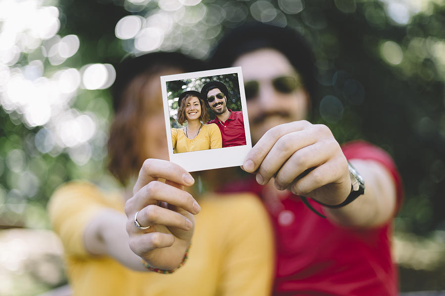 Eccentric couple holding instant photo Photograph by Martin-dm