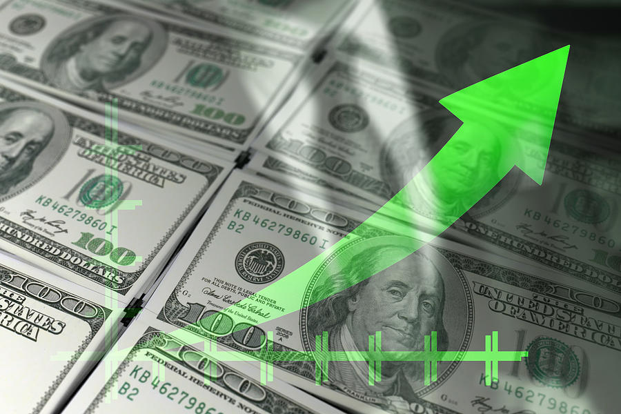 Economy graph: green rising arrow and dollar bills. Photograph by Javier Ghersi