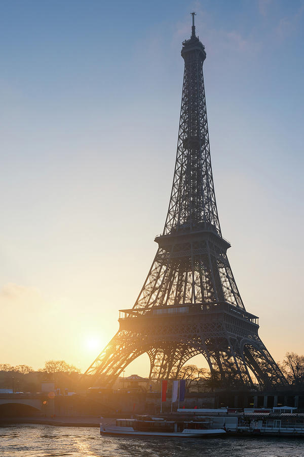 Eiffel tower against sun in Paris Photograph by Philippe Lejeanvre