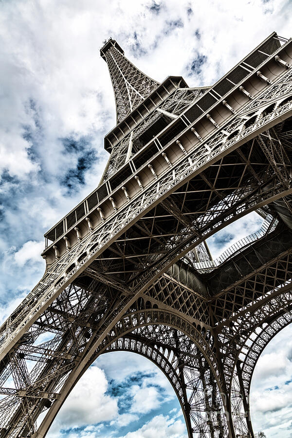 Eiffel Tower with blue sky and cloud background. Low angle view looking up. Built by engineer Gustave Eiffel, and opened in 1889. Champ de Mars, Paris, France. Photograph by Jane Rix