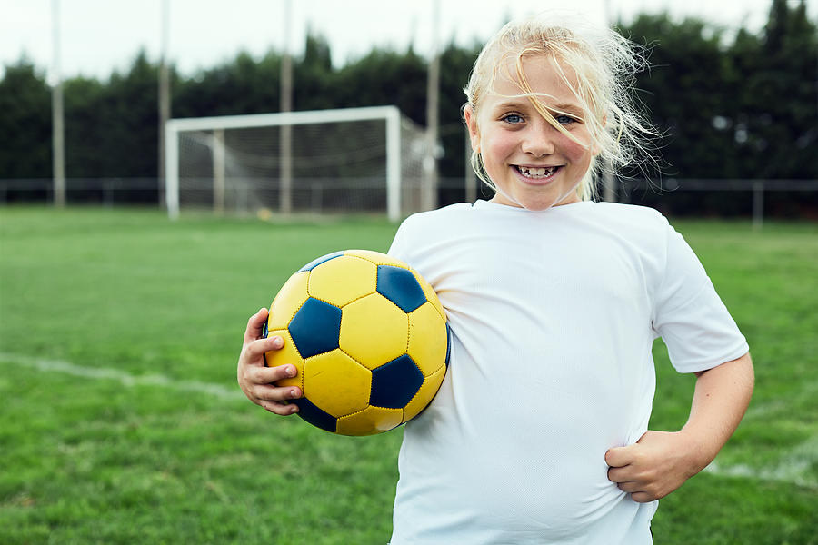 Eight years old soccer player portrait looking at camera. Photograph by Tempura