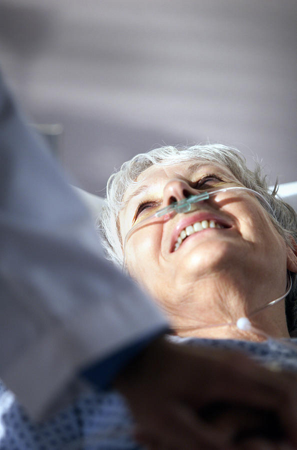 Elderly Caucasian Woman Looks Up And Smiles At Doctor Who Has Come To Visit Her In Hospital Room Photograph by Photodisc