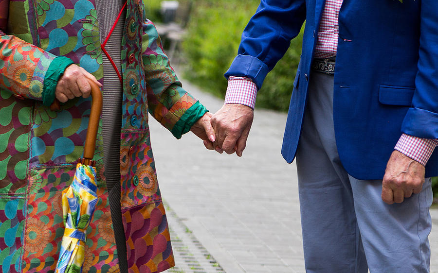 Elderly man and an elderly woman holding hands. Photograph by NataliiaSavina